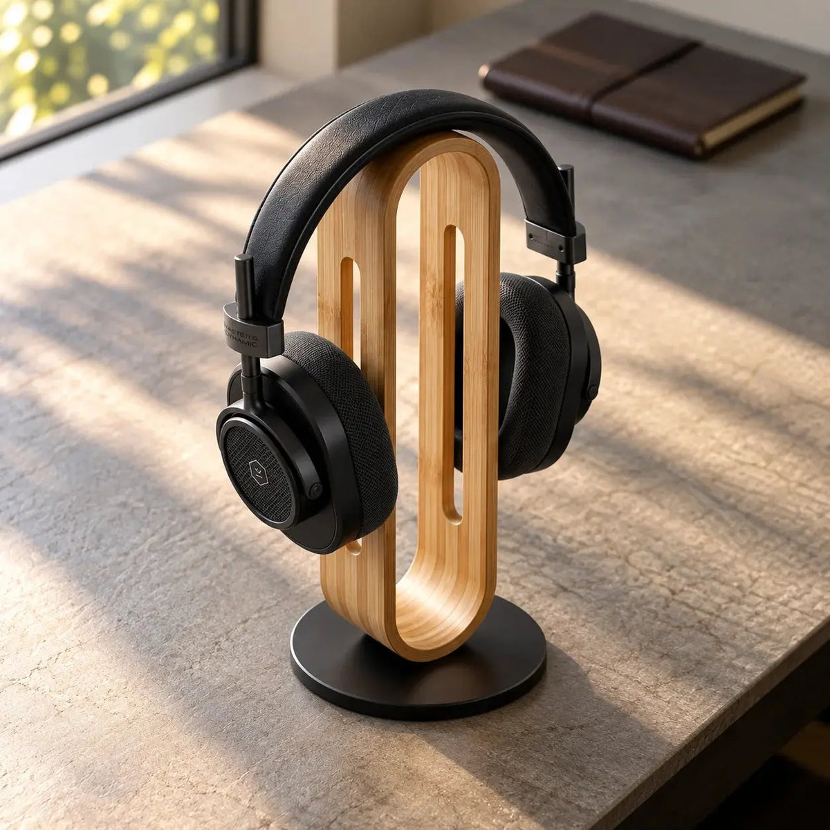 Bamboo wood headphone stand with over-ear headphones and space grey metal base