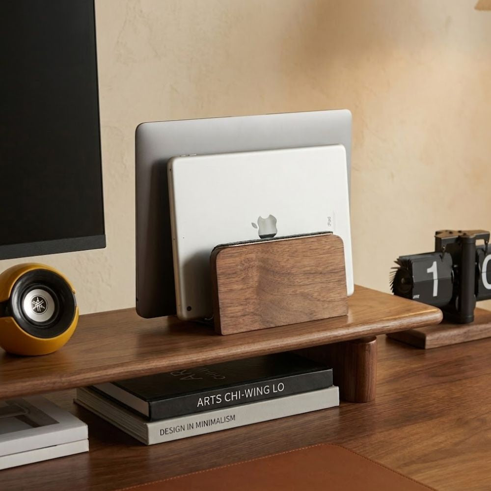 Walnut vertical laptop stand on desk setup with electronic devices and books on a wooden surface