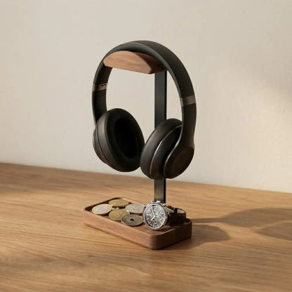 Walnut headphone stand with tray holding headphones on a wooden desk