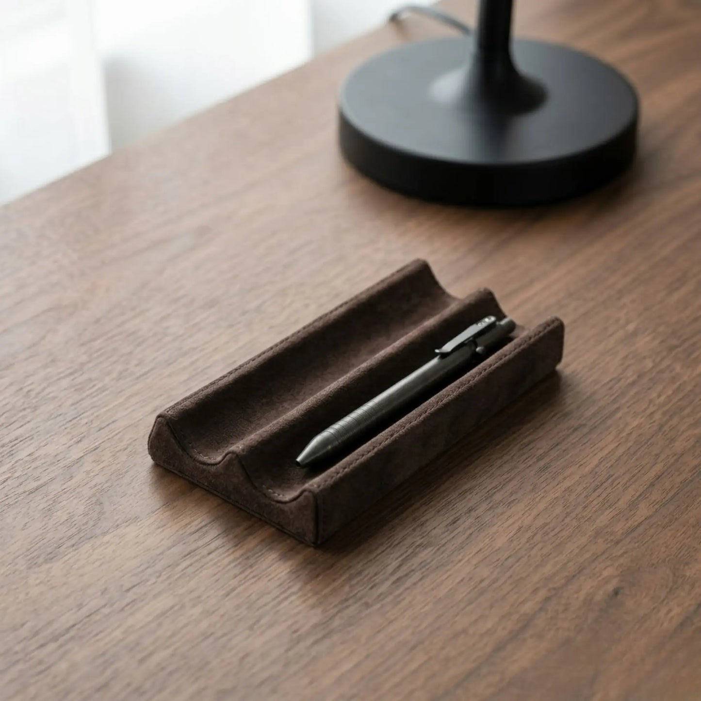 Minimalist leather desk pen tray holding pens on a wooden desk