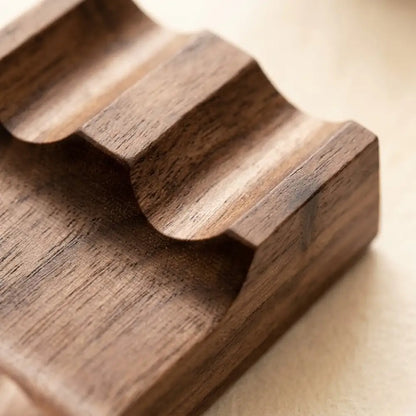 Close-up detail showing precision grooves of a walnut desk pen rest