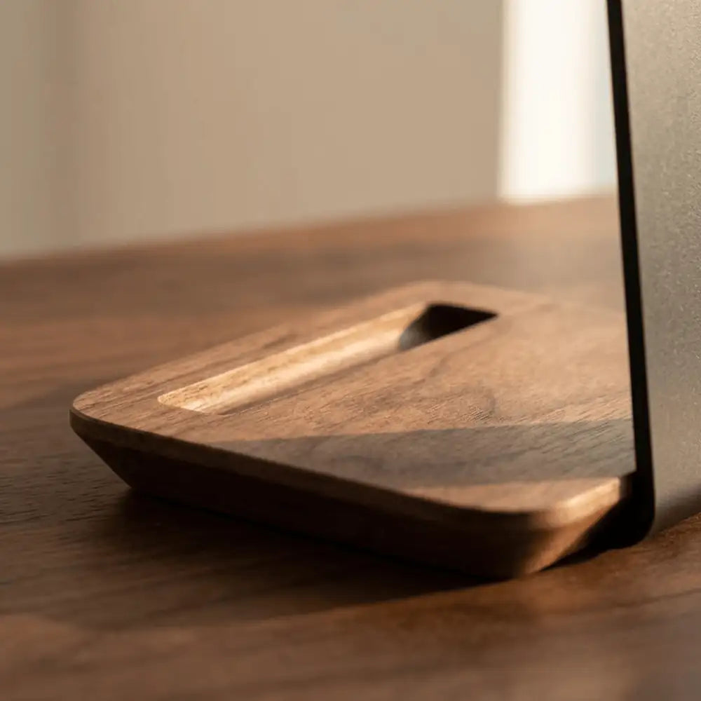 Close-up detail of the carved wooden base on a headphone stand with pen tray.