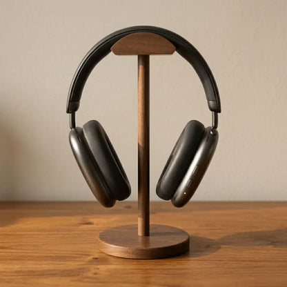Walnut headphone stand for desk holding over-ear headphones on a dark wood surface