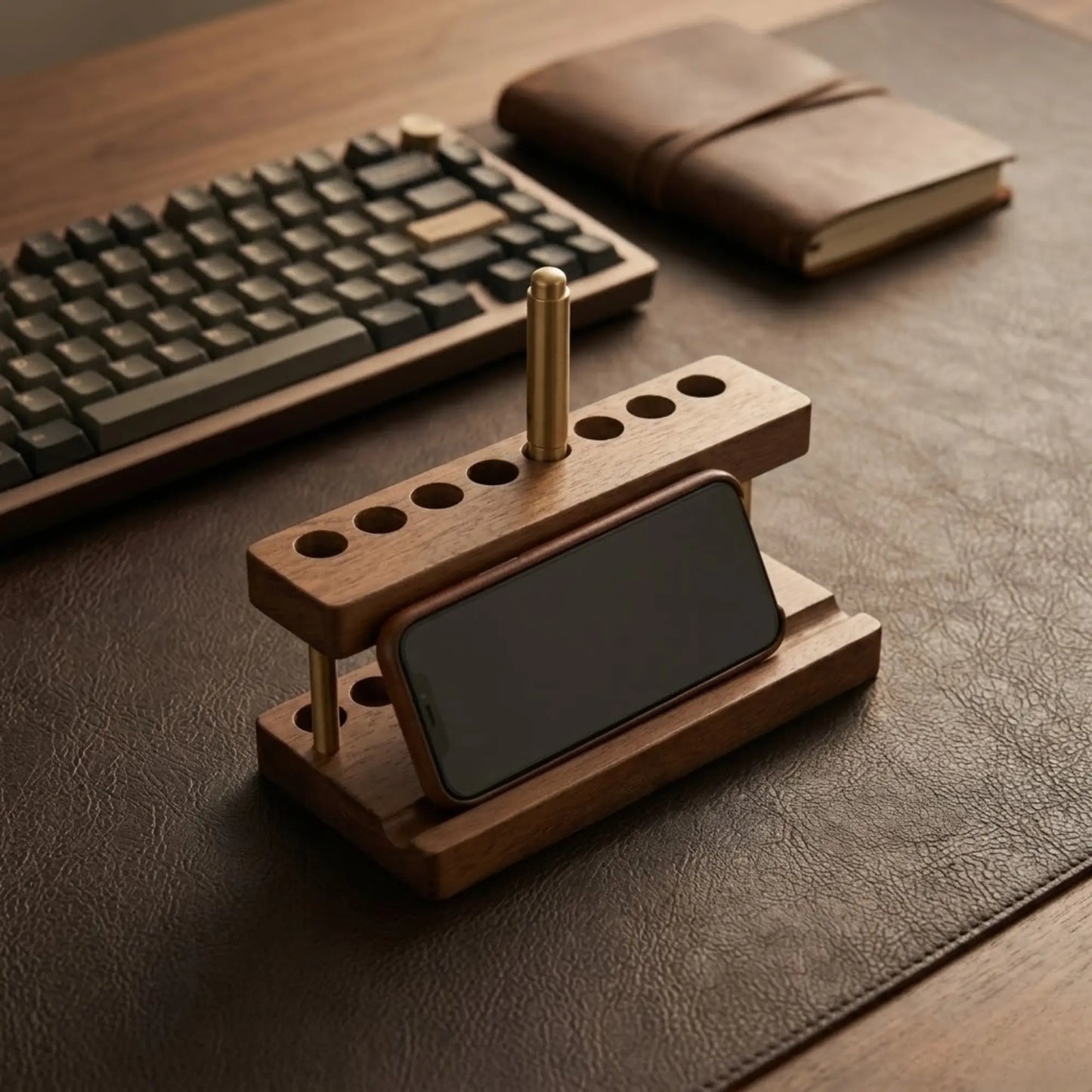 Minimalist walnut desk phone stand holding a smartphone and pens on a wooden desk
