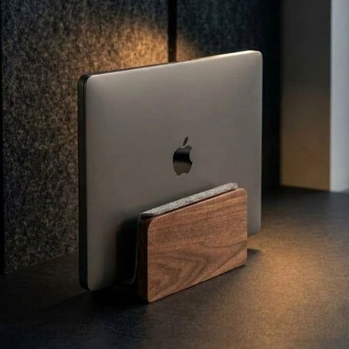 Walnut vertical laptop stand holding a MacBook upright on a desk