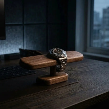 Solid walnut watch display stand holding an everyday watch on a dark wood desk