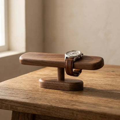 Minimalist walnut watch display stand holding a timepiece in soft natural light