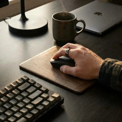Hand using a mouse on a wooden mouse pad in a work desk environment